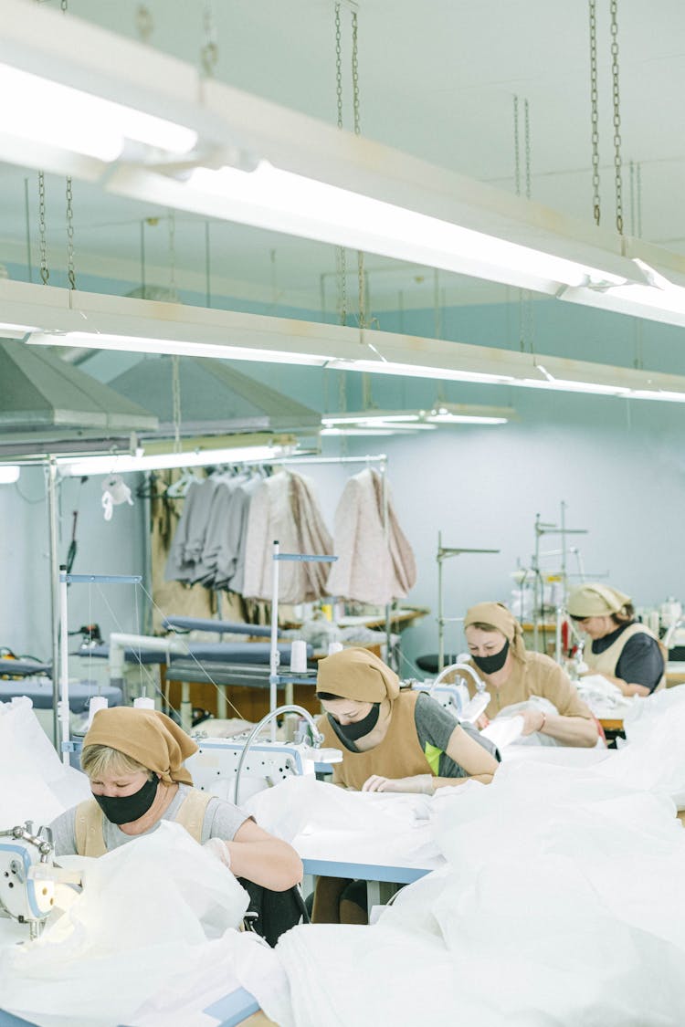 Women Wearing Bandanas And Face Masks Sewing