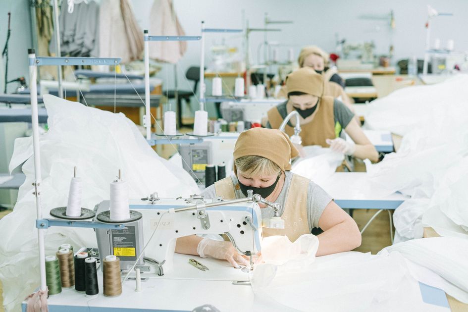 Công nhân nữ vận hành máy may trong xưởng may công nghiệp - quy trình kiểm tra chất lượng vải TR trước khi sản xuất