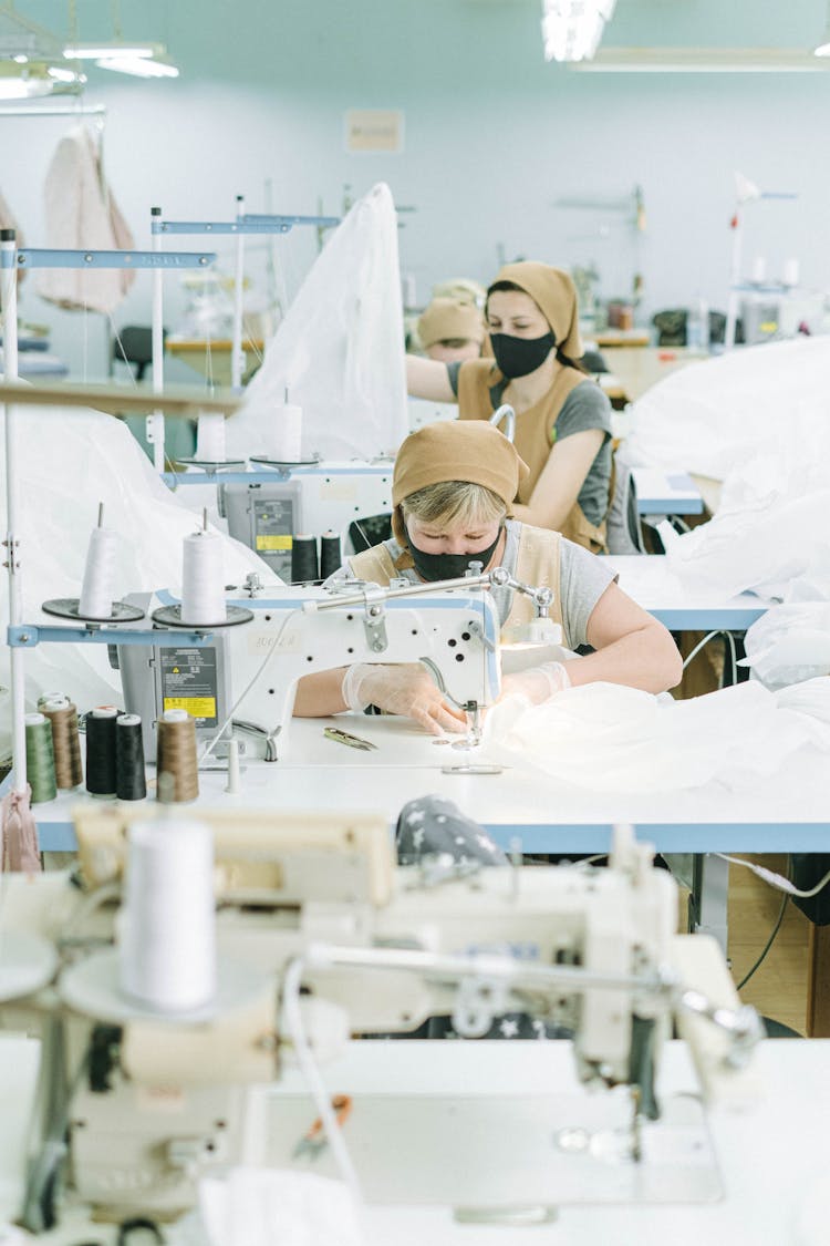 Women In Uniform And Face Masks In A Sewing Factory