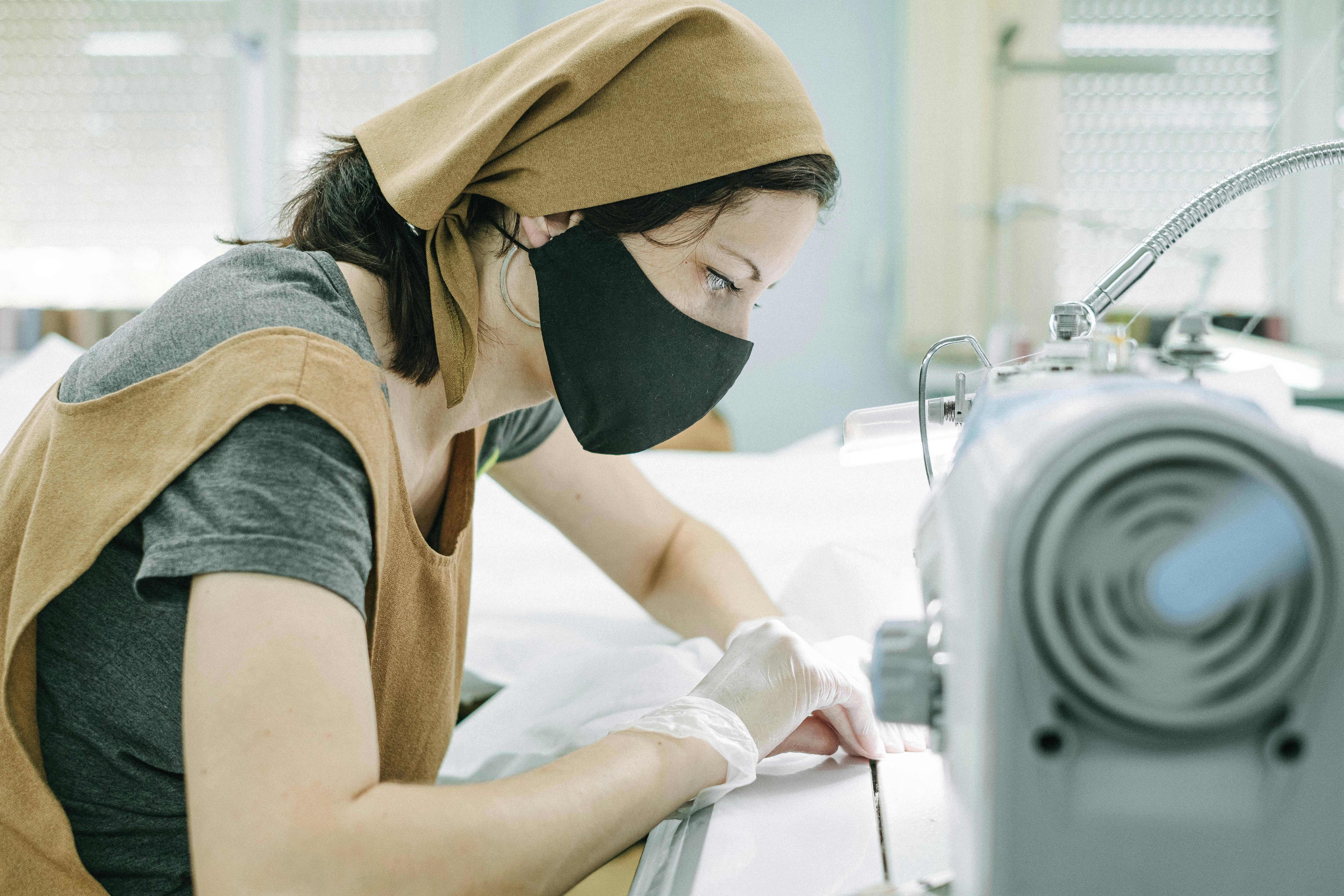 woman in bandana and black face mask working