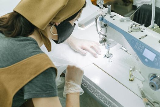 A Woman in Gray Shirt and Brown Bandana Sewing