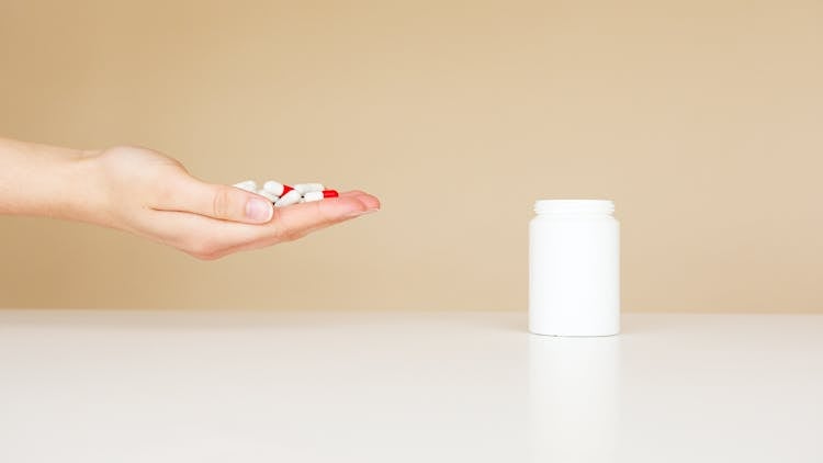 Crop Person With Pile Of Pills In Hand