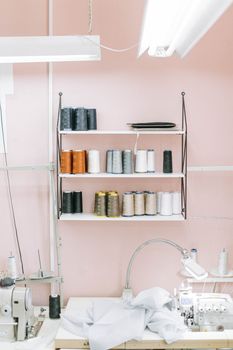 Interior of a sewing studio featuring organized threads, machines, and a clean workspace.