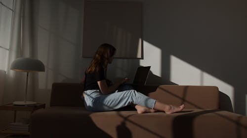 Woman with laptop sitting on couch