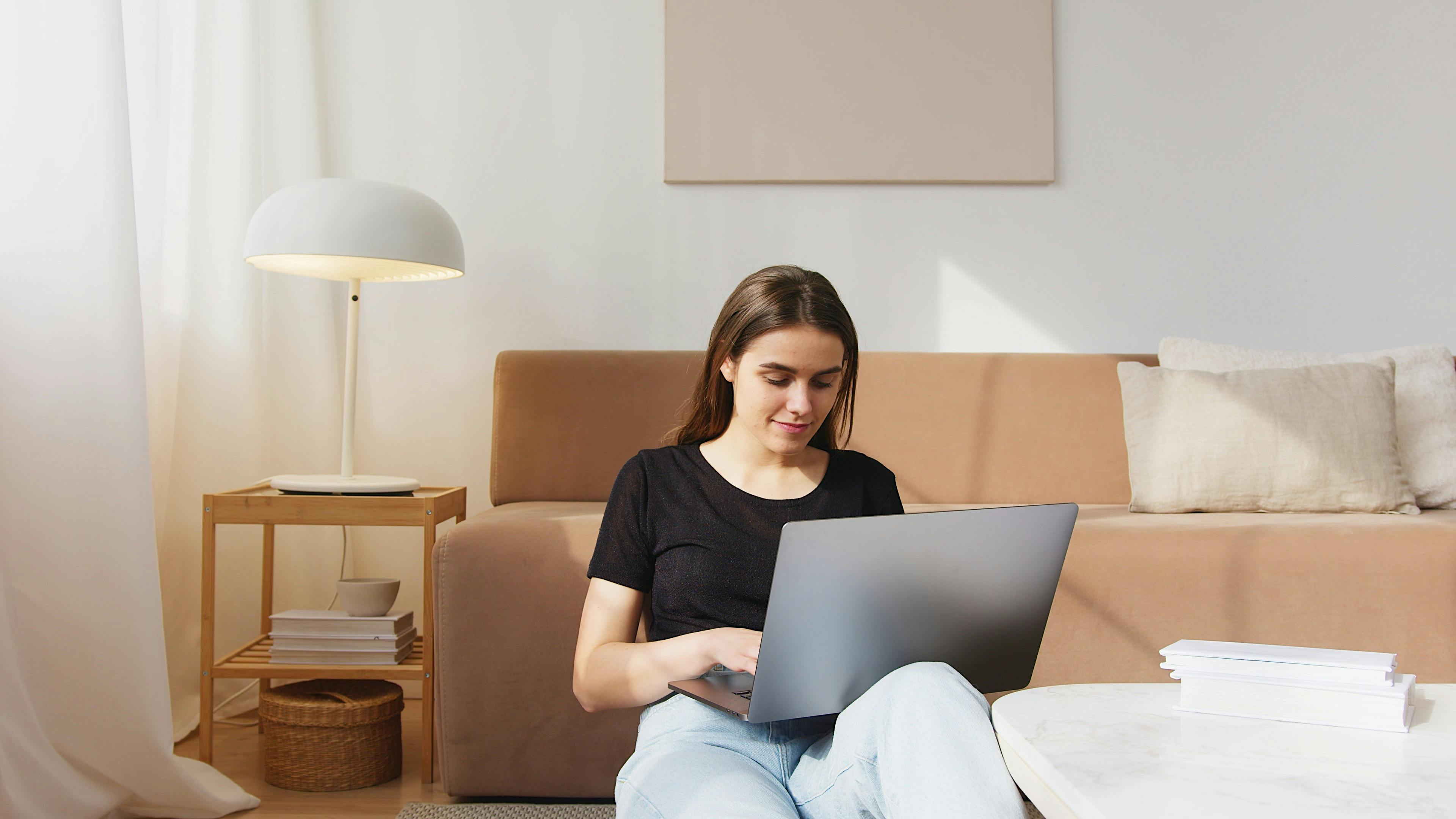 glad young woman working on laptop in living room