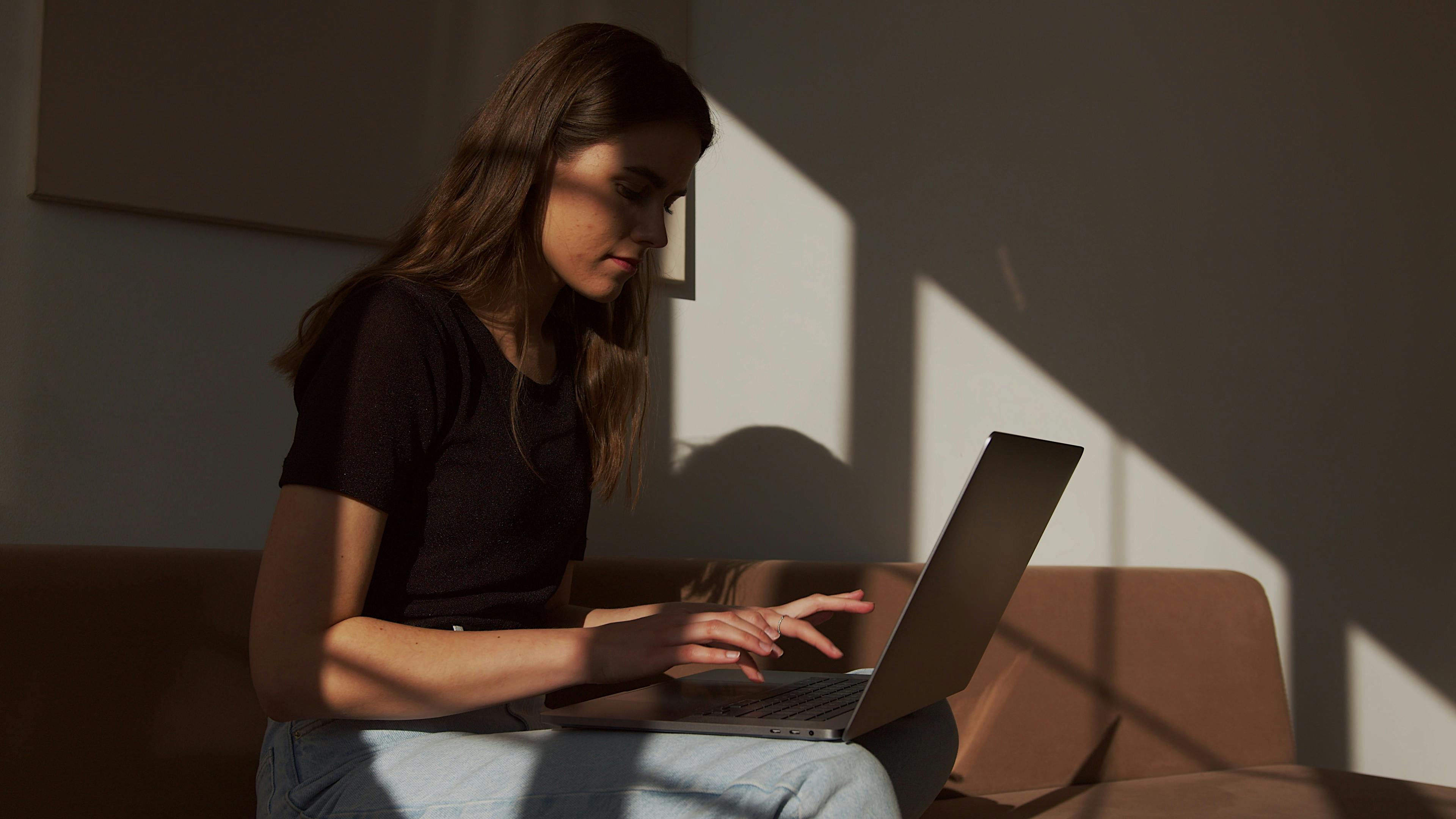 concentrate woman working on laptop on couch