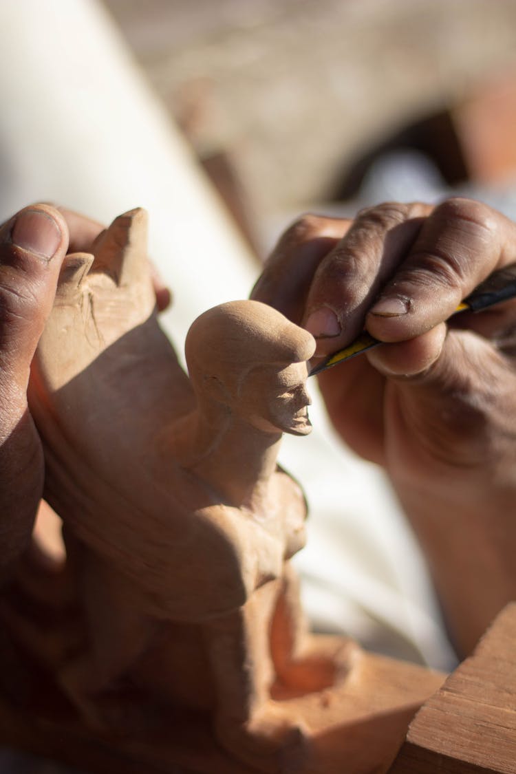 Hand Of A Person Sculpting Using A Sharp Tool