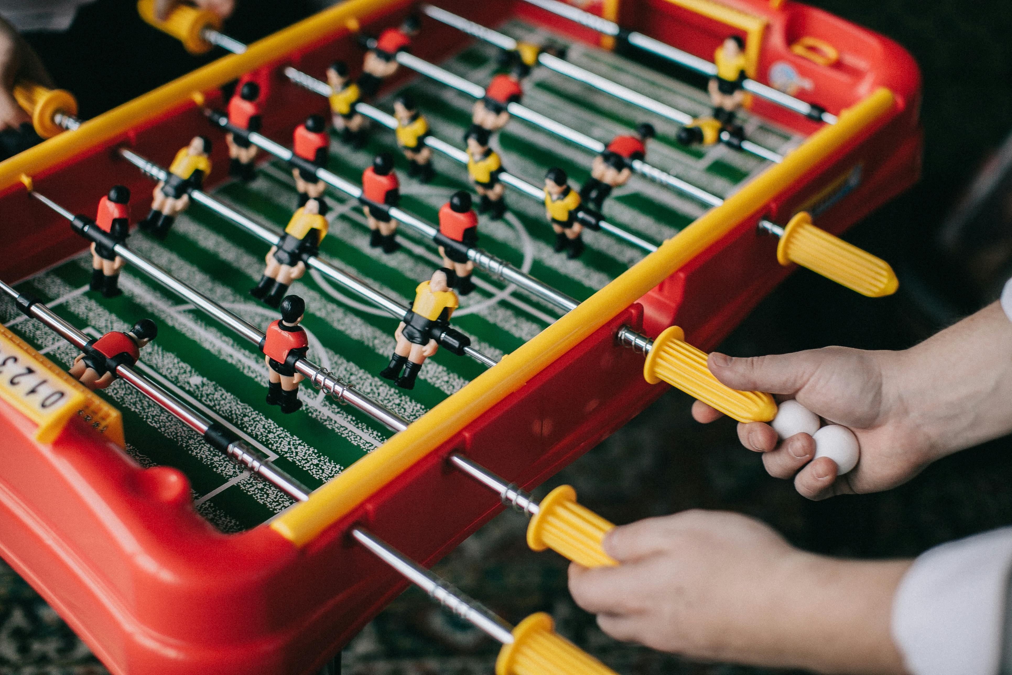 hands of person playing a foosball