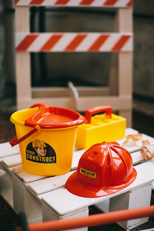 Free Plastic Hard Hat and Bucket Toys on Wooden Crate Stock Photo