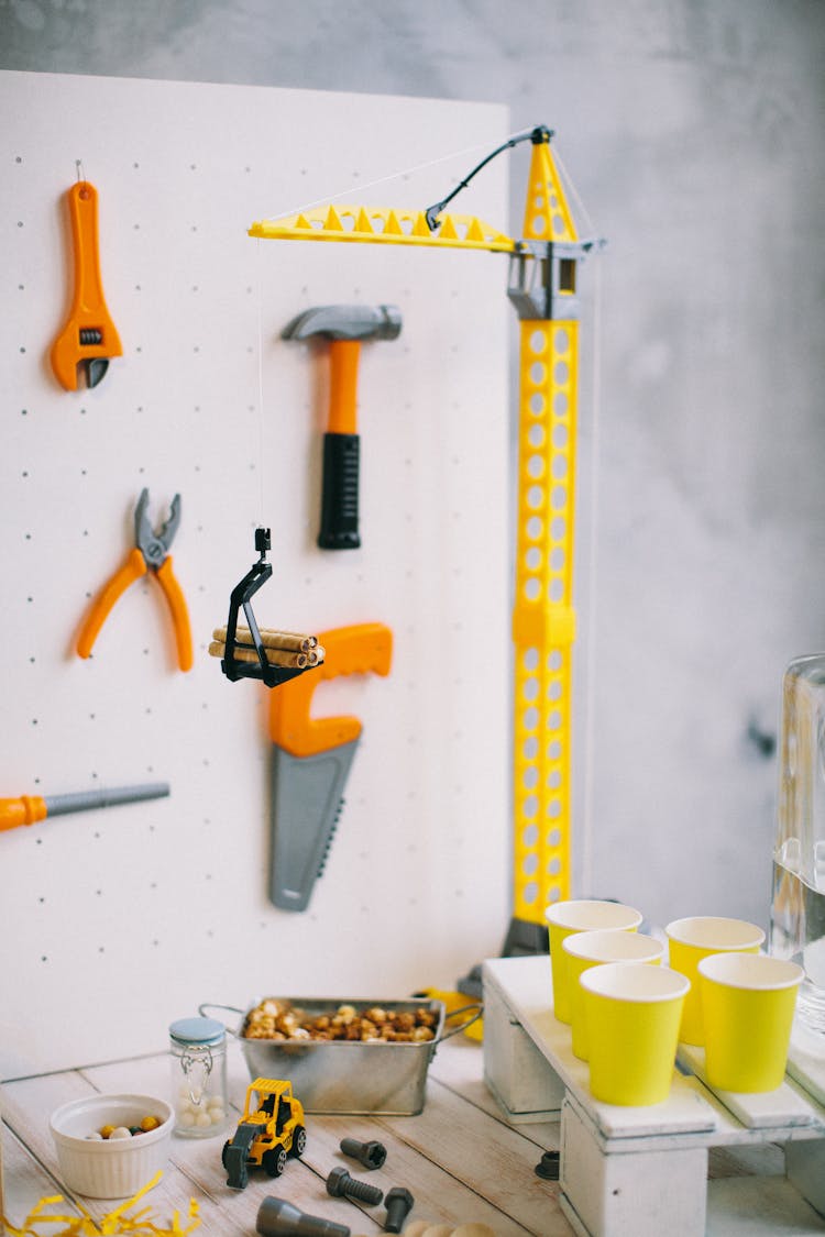 Paper Cups Near A Plastic Toy Crane Tower