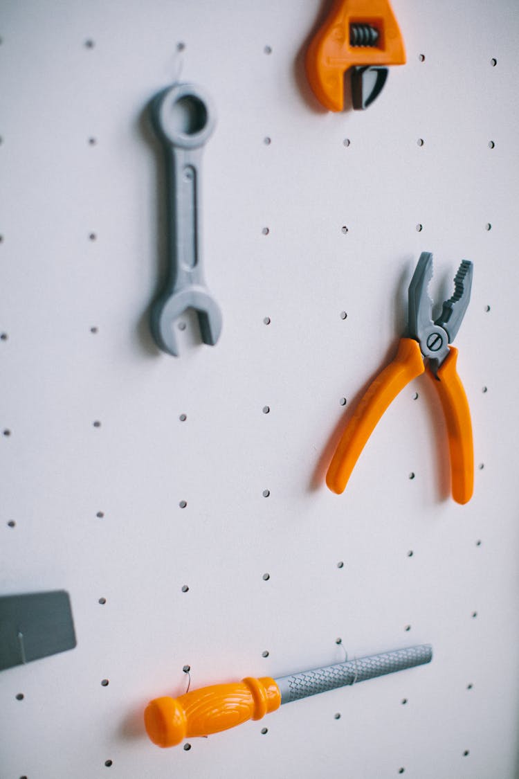 Plastic Pliers And Wrench Toys On A Pegboard