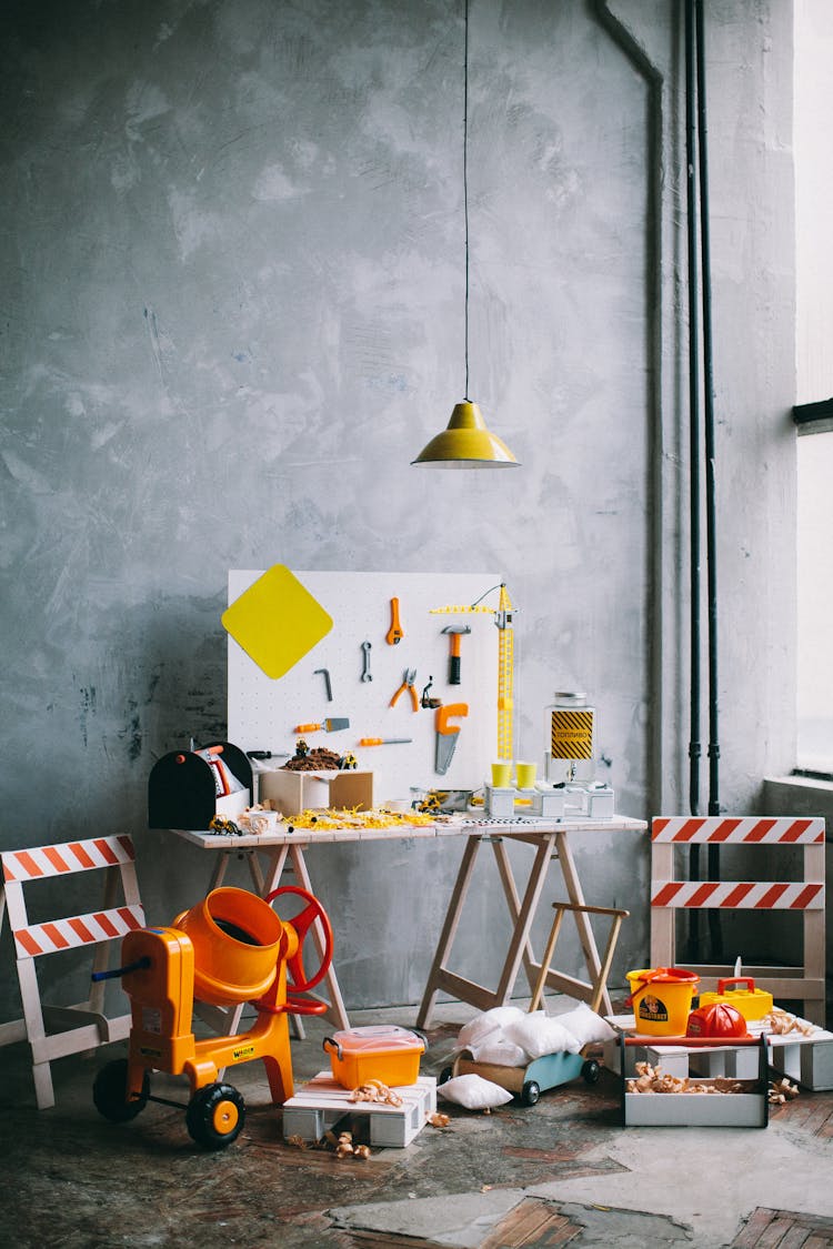 Plastic Toy Cement Mixer And Assorted Toy Tools On A Pegboard