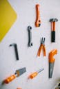 Orange and Gray Plastic Toy Tools on a White Pegboard