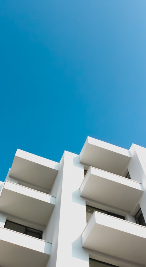 Free White Concrete Building With Balconies Under Blue Sky Stock Photo