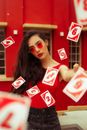 Beautiful woman throwing playing cards in air