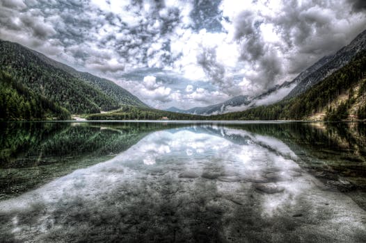 山间宁静的湖泊倒映着云层与松林，构成了一幅令人惊叹的风景