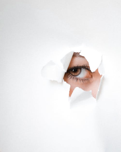 Eye of a Person Peeking Through a Hole 