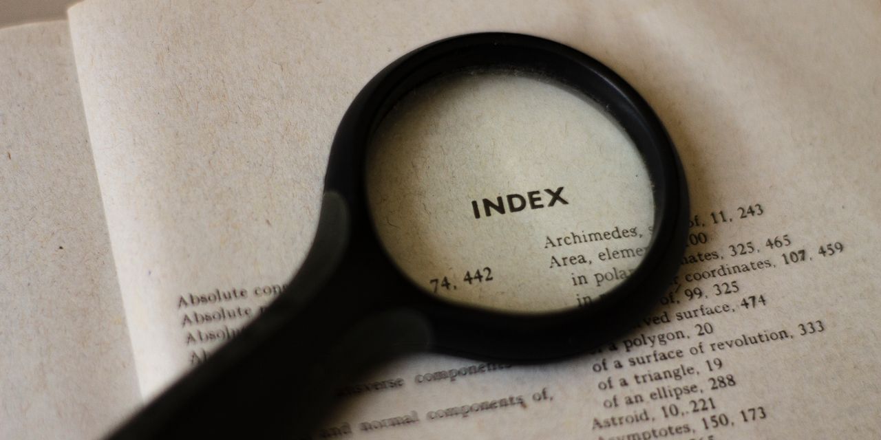 Magnifying glass emphasizing the index of a book, symbolizing research and focus.