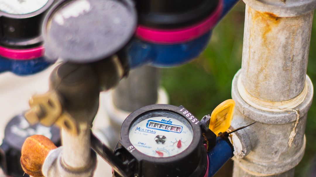 A water meter on its pipework. Read twice with nothing running, it settles most bill arguments on its own.