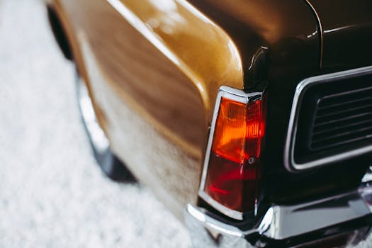 Detailed view of a classic car's amber-colored rear lamp in a vintage style setting.