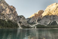 捕捉宁静的反射湖之美，它被高耸的山脉和郁郁葱葱的森林所环绕