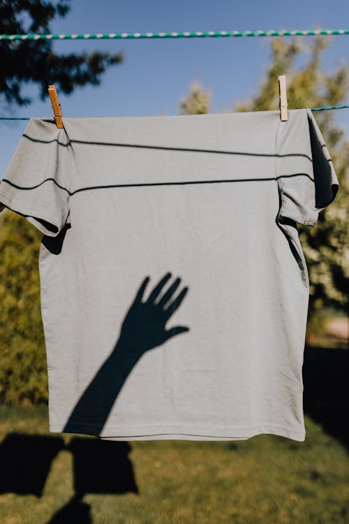 Hanging linen with shadow of person in garden