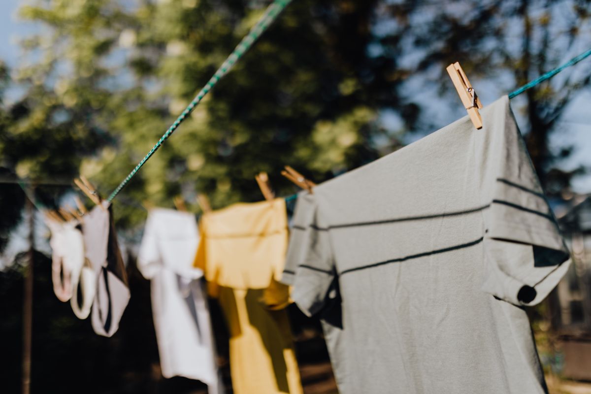 Row of washing pegged to an outdoor clothesline drying in bright sunshine