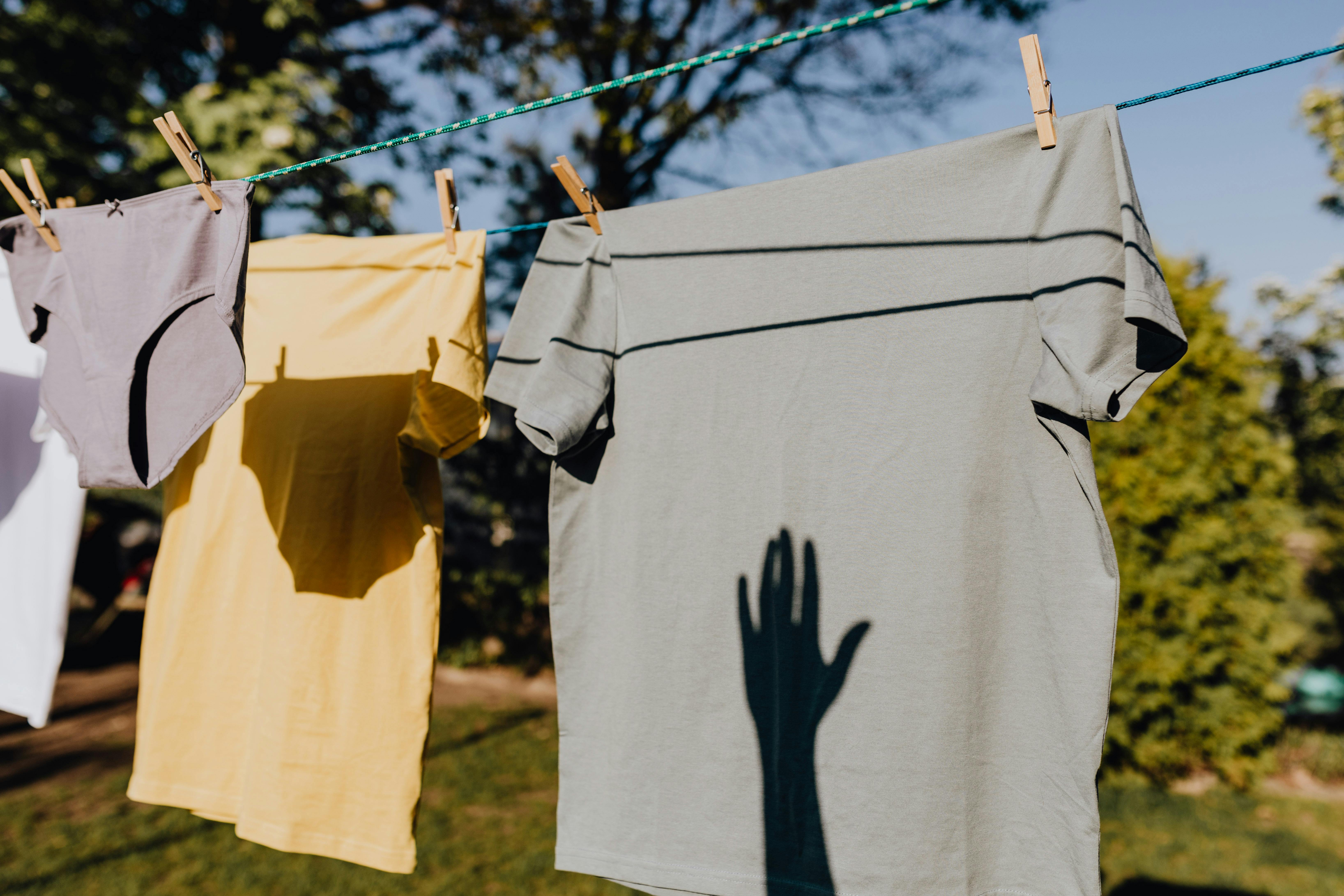 Clothes drying on rope with clothespins in garden · Free Stock Photo
