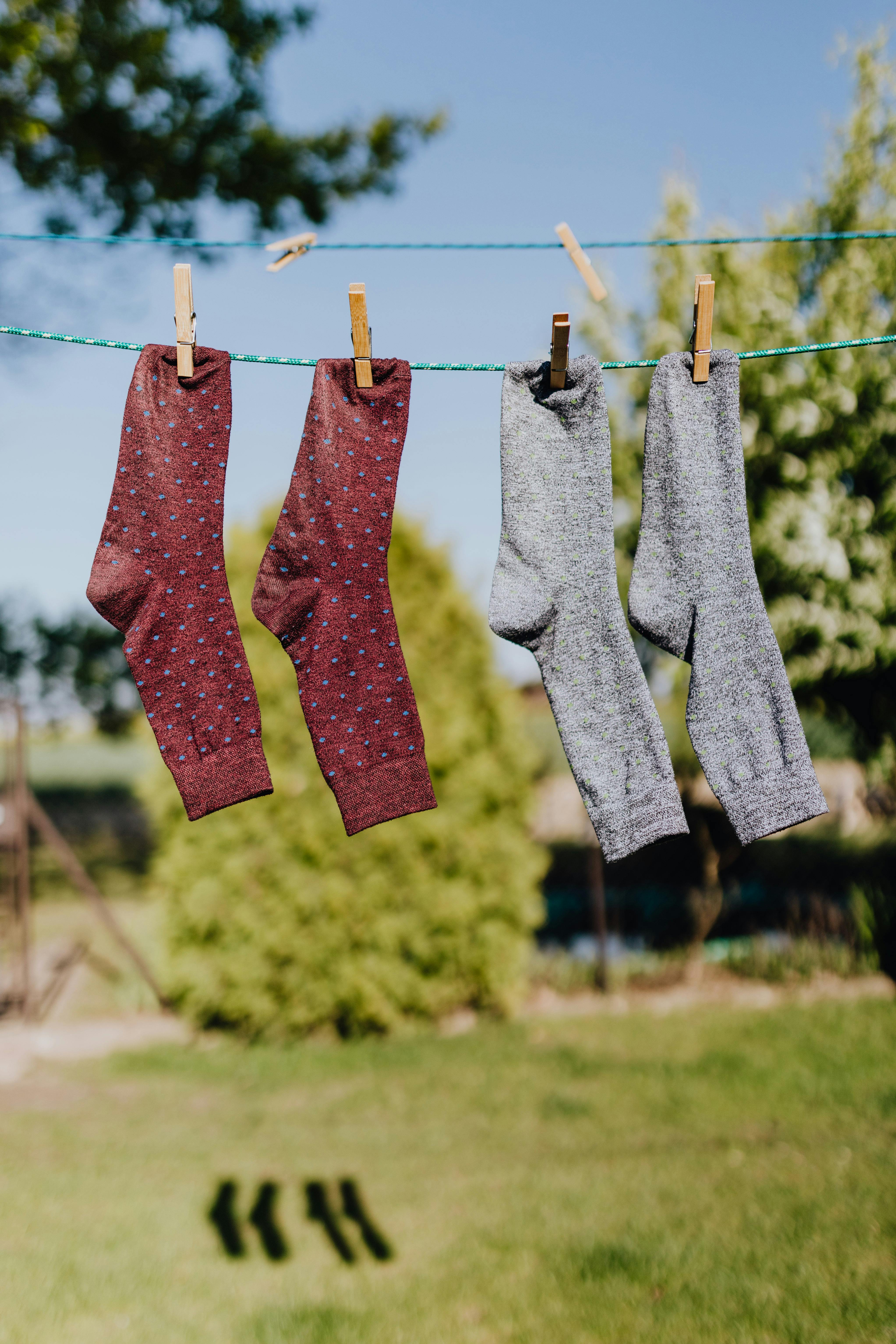 Multicolored socks drying on rope with clothespins in garden · Free Stock  Photo