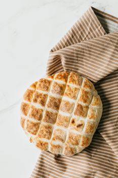 俯视白色大理石餐桌上条纹餐巾纸上的开胃面食面包
