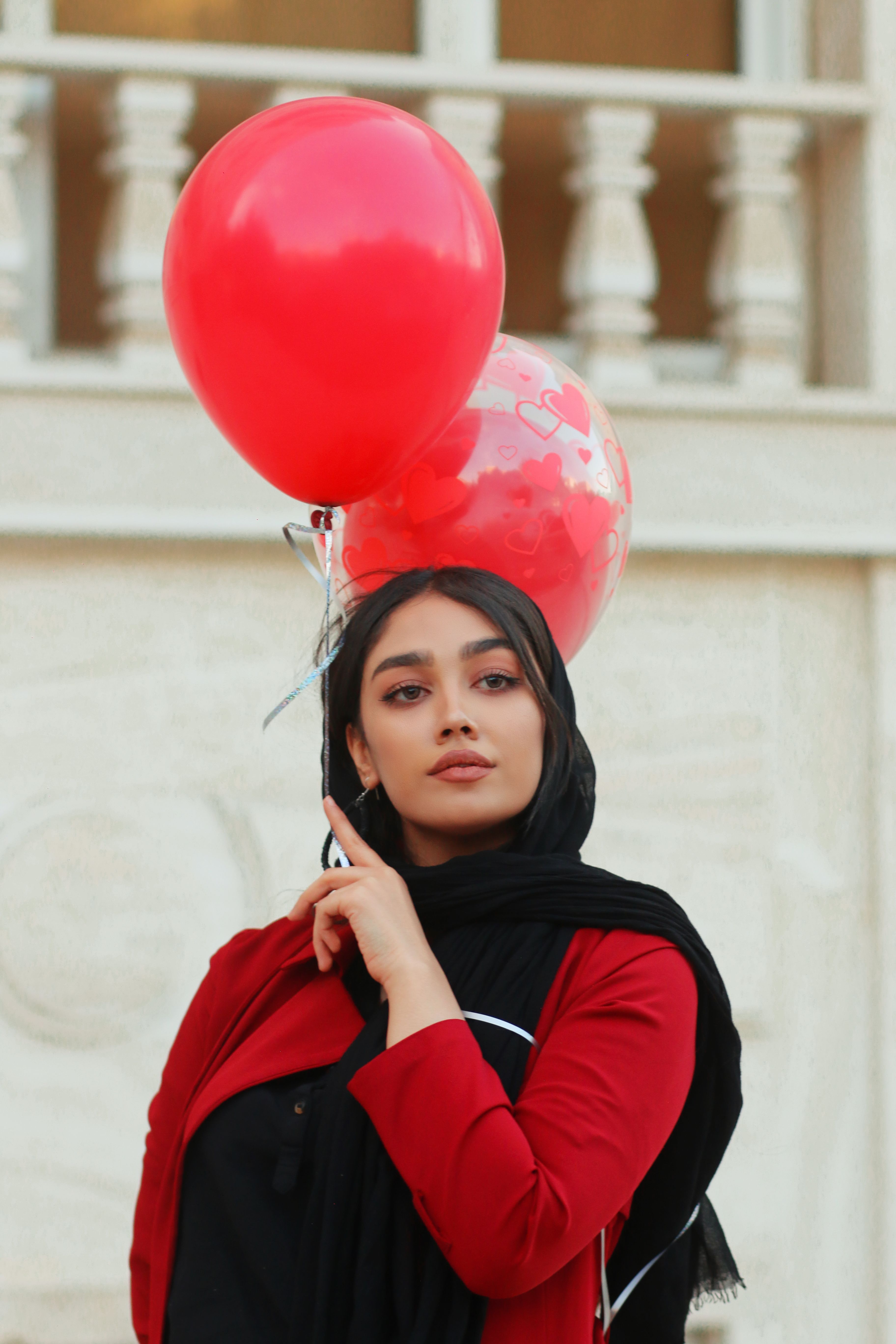 Woman in Zanjan wearing a hijab with red balloons in hand.