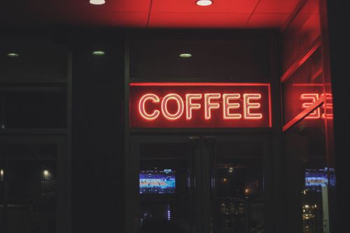 Free A vibrant neon coffee sign illuminating a modern cafe environment at night. Stock Photo