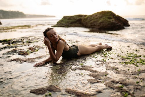 Young woman lying on quiet sandy seashore