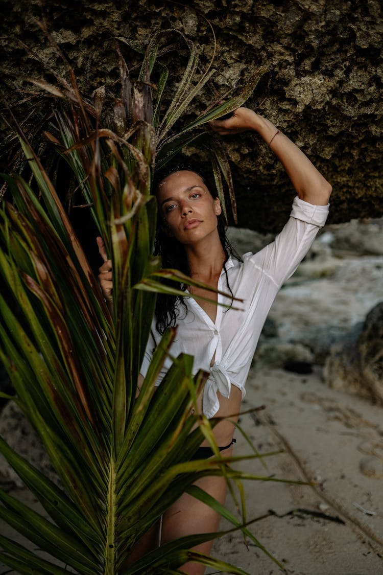 Serious Woman Holding Palm Branch On Seashore