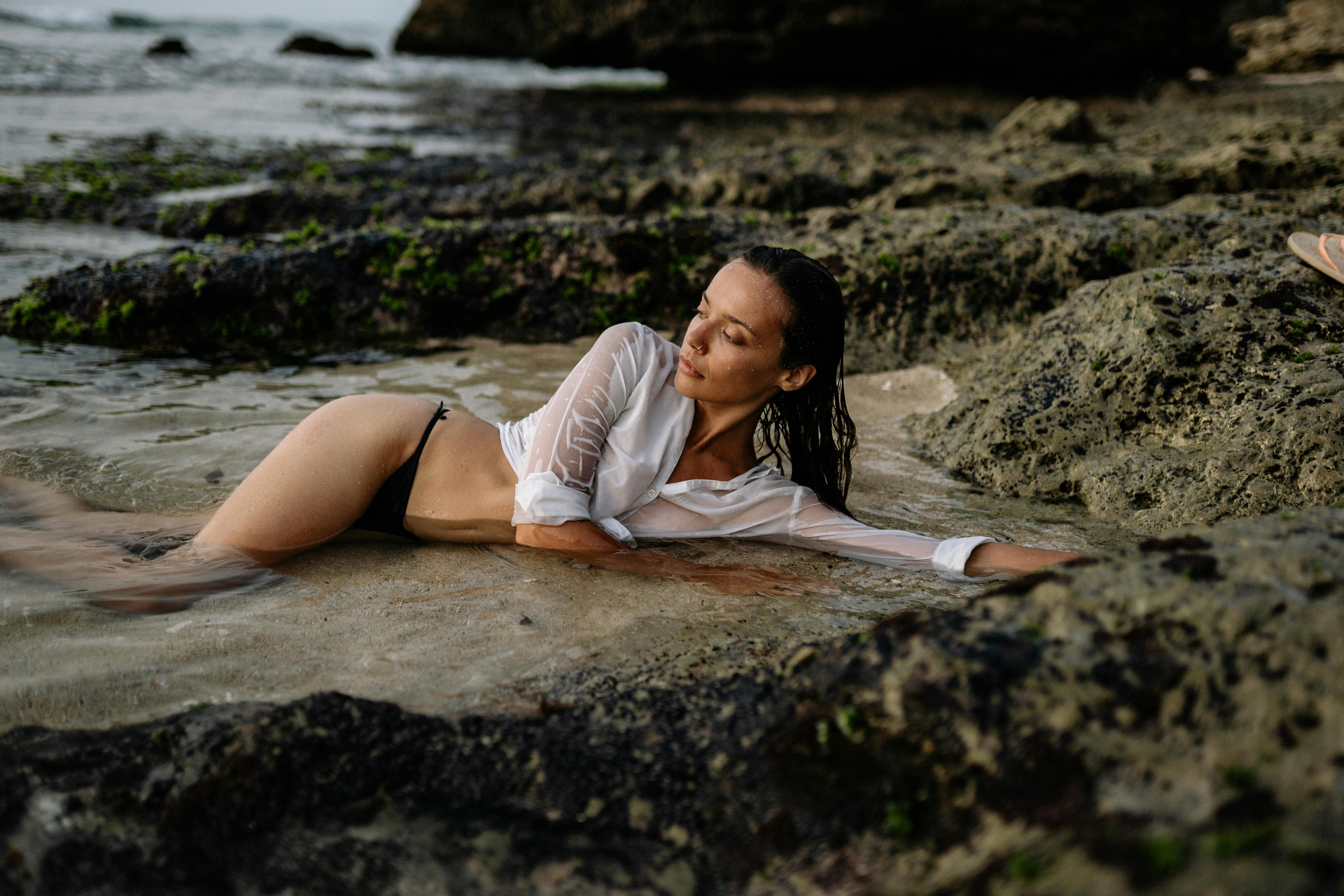 sensual woman lying on sand in sea water