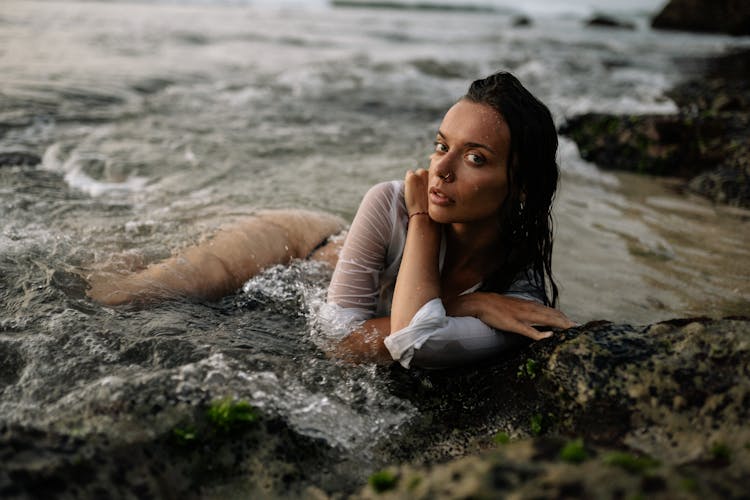 Sensual Woman In Shirt And Bikini Lying On Sandy Beach In Water