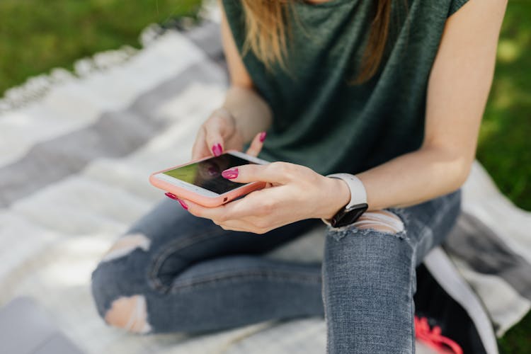 Crop Lady Using Mobile While Sitting In Park