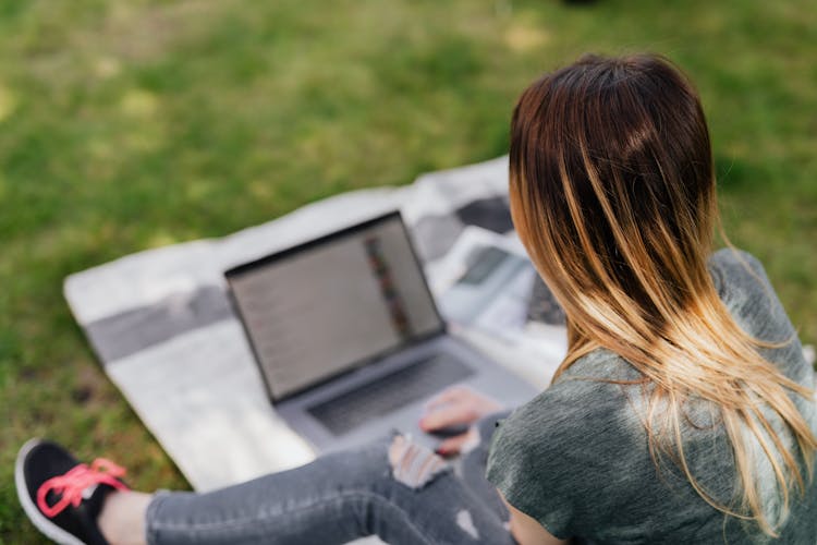 Unrecognizable Teenager Surfing Social Media On Laptop In Green Park