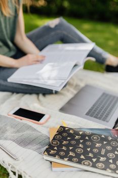 一名学生在户外阳光明媚的地方用笔记本电脑学习和读书