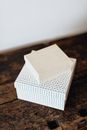 From above carton gift boxes of different sizes stacked together on wooden shabby surface against white wall