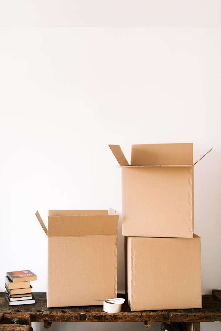 Cardboard Boxes And Books On Wooden Table