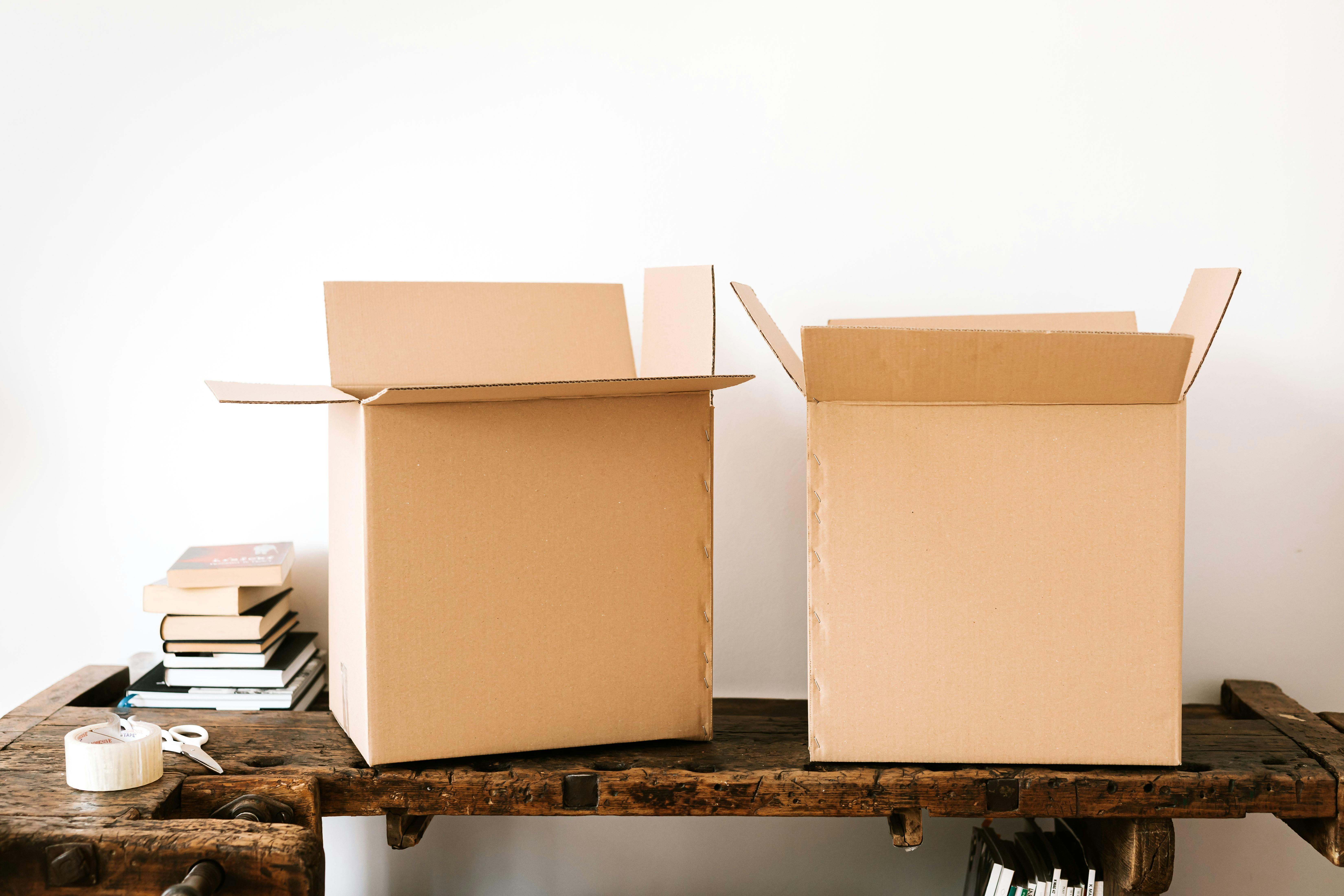 carton boxes and stacked books on table