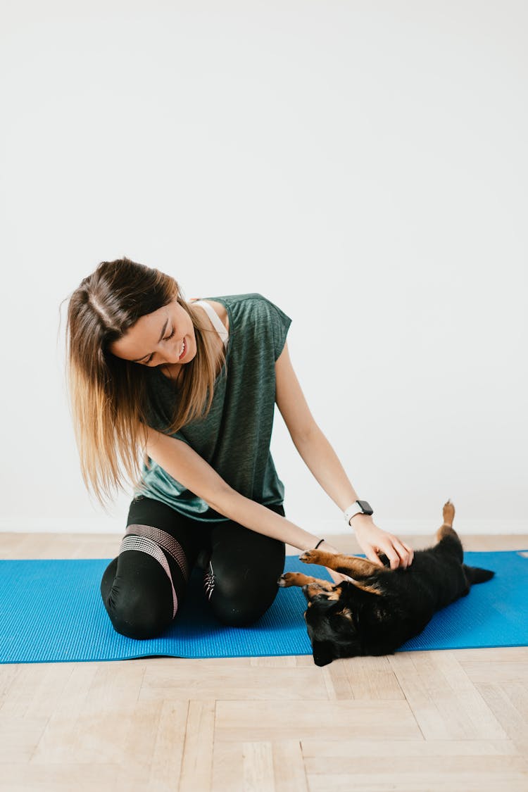 Cheerful Female Playing With Lancashire Heeler On Yoga Mat