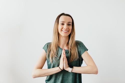 Free Fit smiling lady standing with Prayer hands while practicing yoga Stock Photo