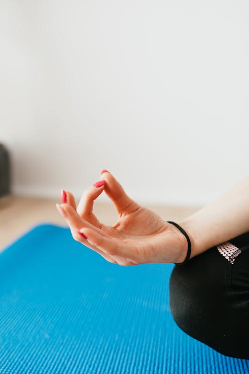 Free Crop unrecognizable woman meditating in Lotus pose at home Stock Photo