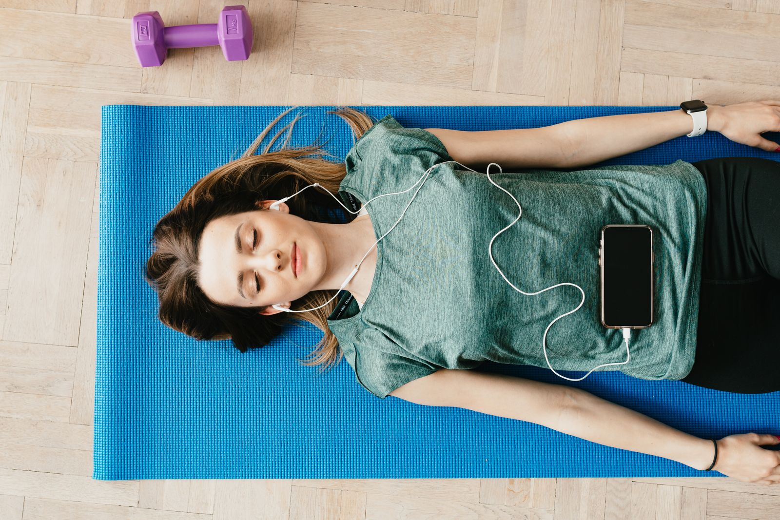 Woman resting comfortably at home in a guided meditation pose with eyes closed