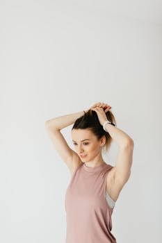 一位年轻女子扎着马尾辫，在白色背景下显得自信又时尚