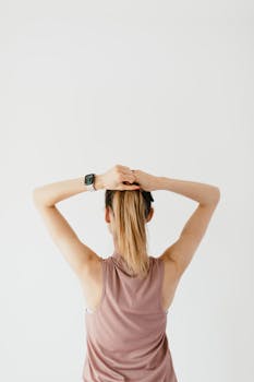 一位苗条的无脸年轻女性，穿着运动服，用橡皮筋绑着头发，只留下背影