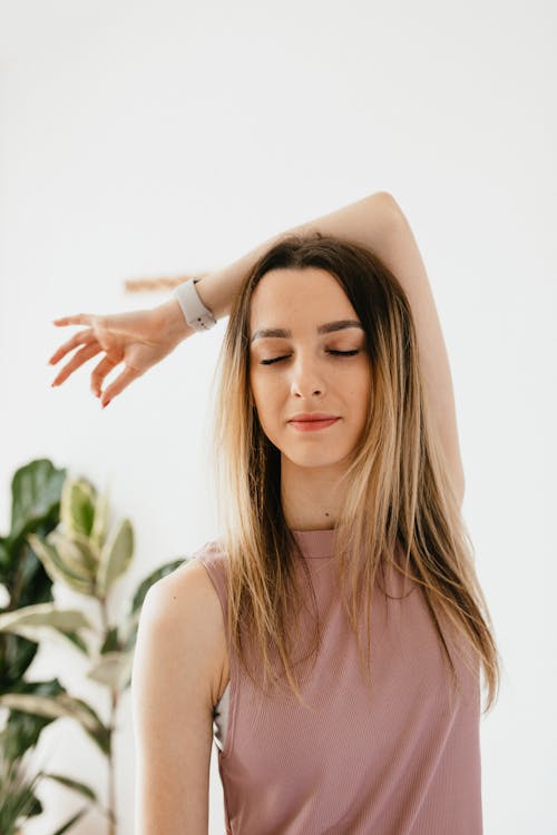 Free Positive young relaxed female meditating with closed eyes and fingers in Gyan mudra during yoga training at home Stock Photo