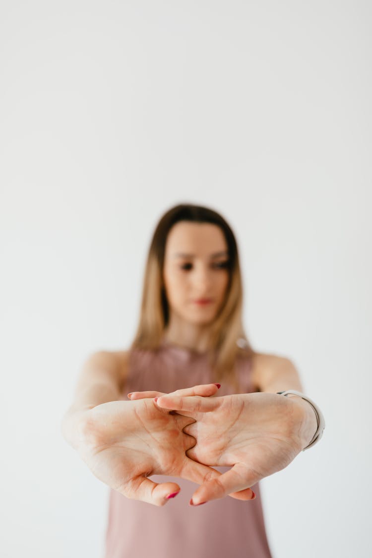 Concentrated Young Lady Warming Up Hands Before Training